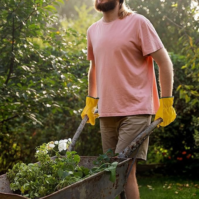 person with leather garden gloves pushing a wheelbarrow